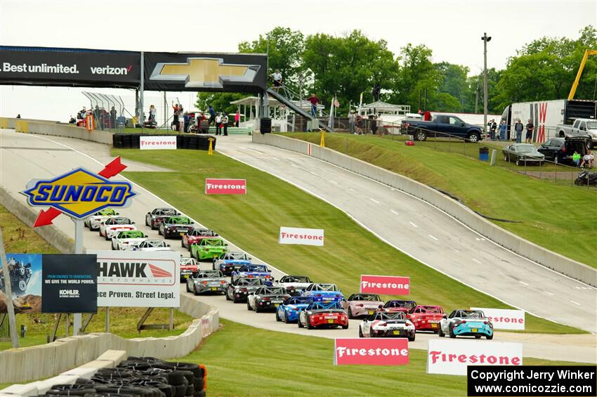 The Mazda MX-5 Cup field heads uphill to the green flag.