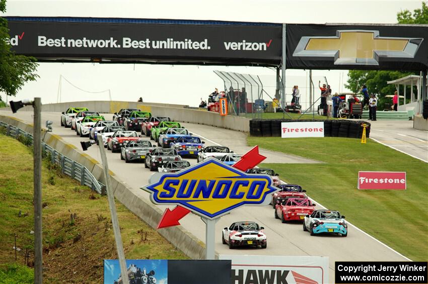 The Mazda MX-5 Cup field heads uphill to the green flag.