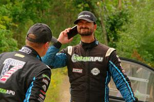 John Hall sprays insect repellant on Patrick Gruszka after their Hyundai i20 R5 stalled on SS11, Otterkill I.