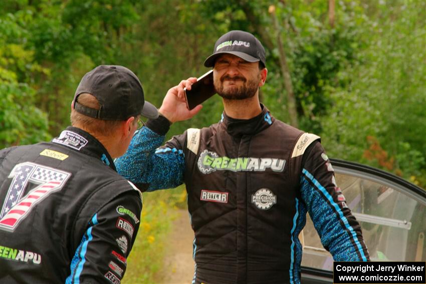 John Hall sprays insect repellant on Patrick Gruszka after their Hyundai i20 R5 stalled on SS11, Otterkill I.