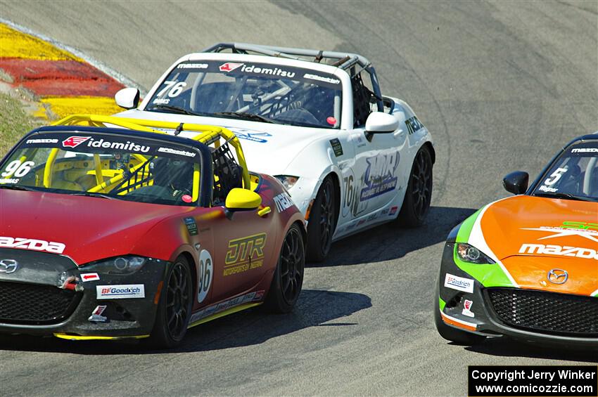 Jared Thomas and Matthew Dirks pass Gresham Wagner, all in Mazda MX-5 Cups.