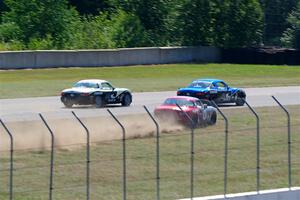 Kyle Greenhill's and Samantha Silver's Spec Miata Mazda Miatas pass Chris Craft's Spec Miata Mazda Miata