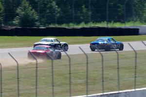 Kyle Greenhill's and Samantha Silver's Spec Miata Mazda Miatas pass Chris Craft's Spec Miata Mazda Miata