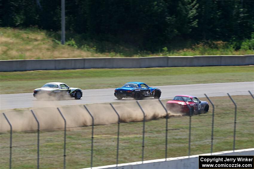 Kyle Greenhill's and Samantha Silver's Spec Miata Mazda Miatas pass Chris Craft's Spec Miata Mazda Miata