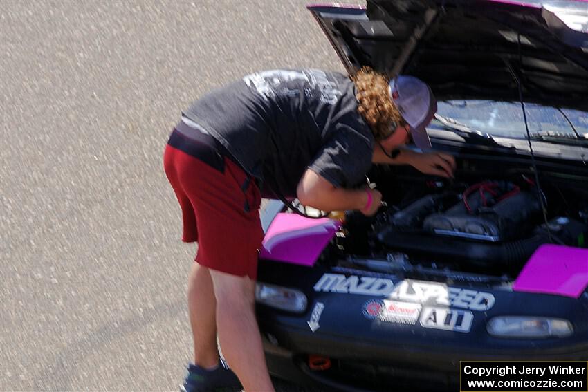 Andrew Rausch checks under the hood of Sophie Jones' Spec Miata Mazda Miata.