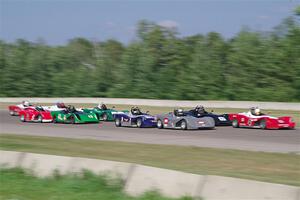 Spec Racer Ford 3s file into turn one on the first lap.
