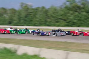 Spec Racer Ford 3s file into turn one on the first lap.
