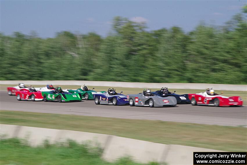 Spec Racer Ford 3s file into turn one on the first lap.