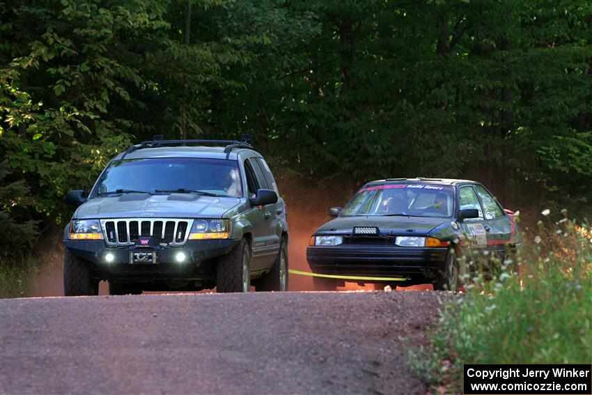 A Jeep Grand Cherokee sweeps the Joe Boburka / Elizabeth Unglenieks-Ploeg Ford Escort from SS5, Norway South II.
