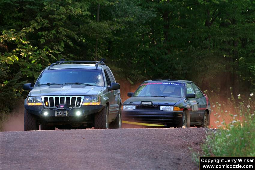 A Jeep Grand Cherokee sweeps the Joe Boburka / Elizabeth Unglenieks-Ploeg Ford Escort from SS5, Norway South II.