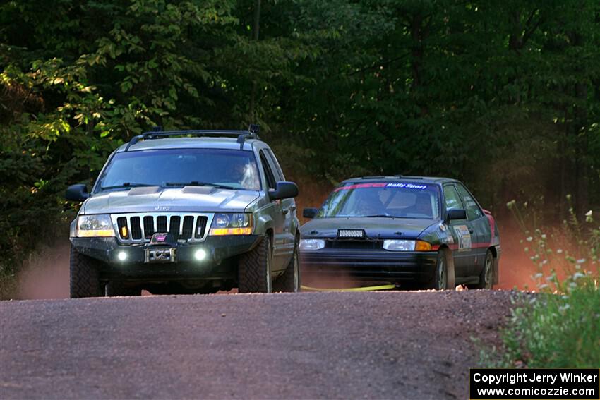 A Jeep Grand Cherokee sweeps the Joe Boburka / Elizabeth Unglenieks-Ploeg Ford Escort from SS5, Norway South II.