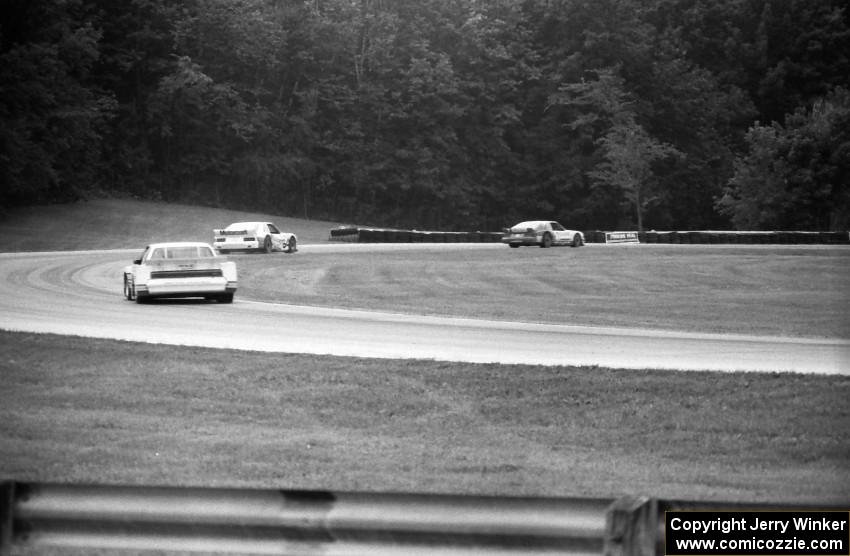 Tom Gloy's Mercury Capri ahead of Chris Kneifel's Mercury Capri and Elliott Forbes-Robinson's Buick Somerset in the carousel.