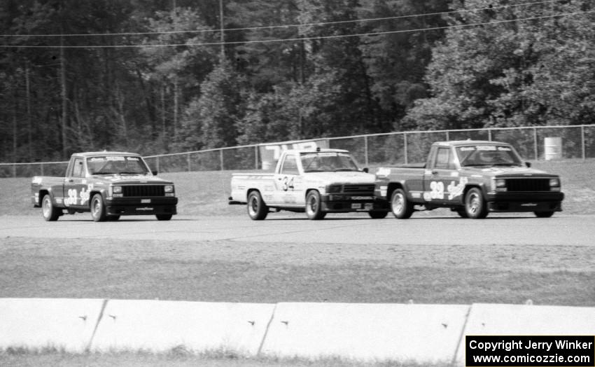 Bobby Archer's Jeep Comanche leads Steve Lewis' Toyota Pickup and Tommy Archer's Jeep Comanche during the race.