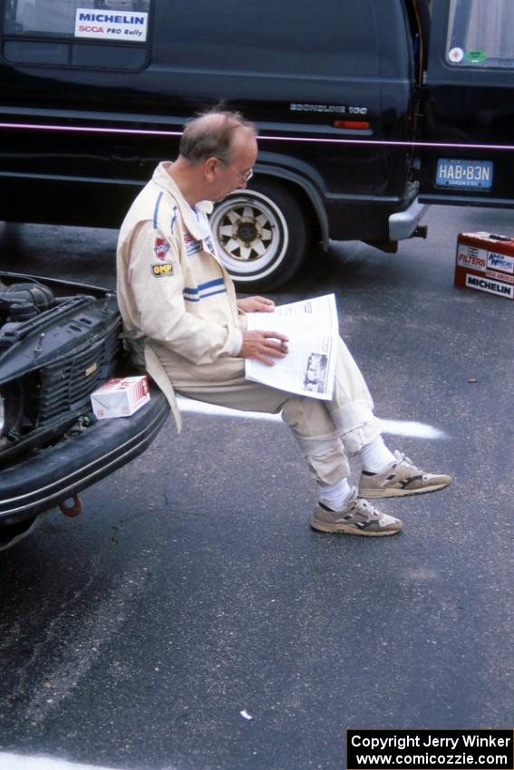 Stuart Spark reads over a copy of the NINES newsletter on the bumper of the SAAB 99EMS he and Jerry Sweet shared.