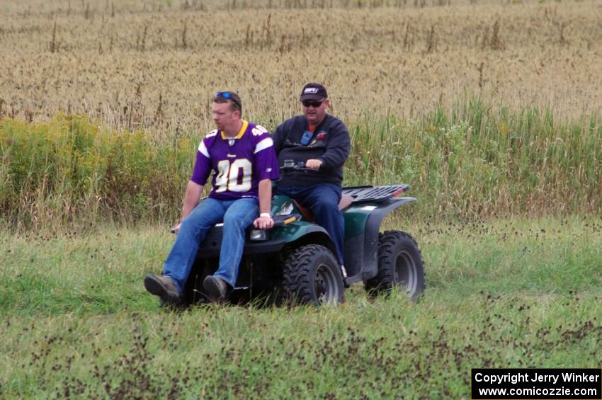 Mark Utecht drives the ATV while Brian Chabot checks for things on the racing line