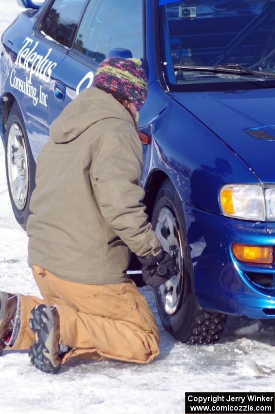 Carrie Carlson tightens the lugs on the Mark Utecht / Brent Carlson / David Steen, Sr. / Matt Shaefer Subaru Impreza 2.5RS