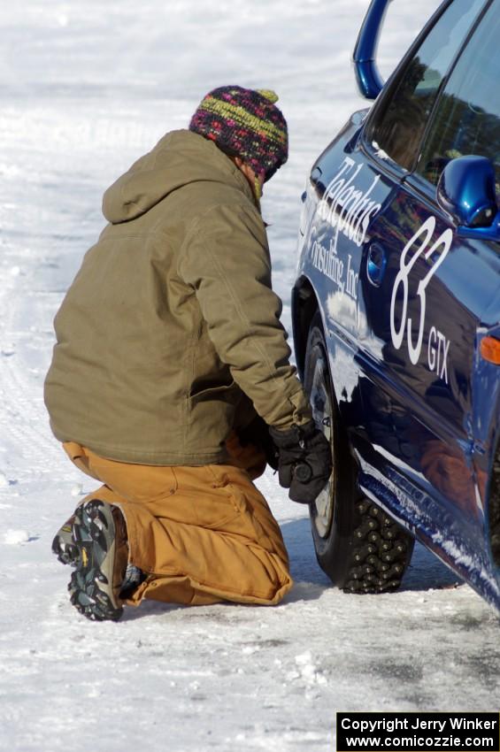 Carrie Carlson tightens the lugs on the Mark Utecht / Brent Carlson / Dave Steen, Sr. / Matt Shaffer Subaru Impreza 2.5RS