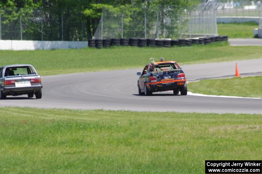 Tubby Butterman BMW 325 passes the Speedlab BMW 325e exiting the carousel