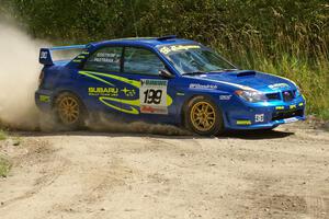 Travis Pastrana / Christian Edstrom Subaru WRX STi slings gravel at a hard left-hander on SS9.