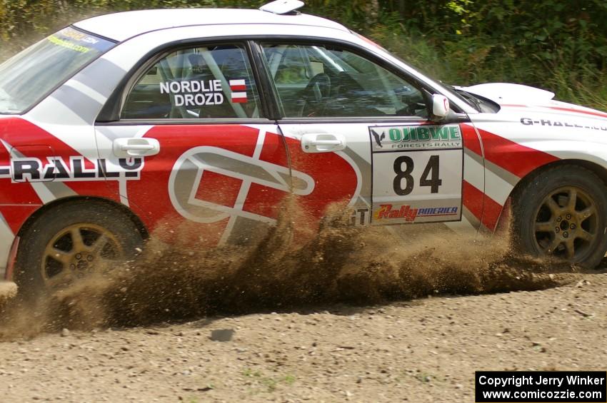 Greg Drozd / John Nordlie sling gravel as they power through a left-hander on SS9 in their Subaru WRX.