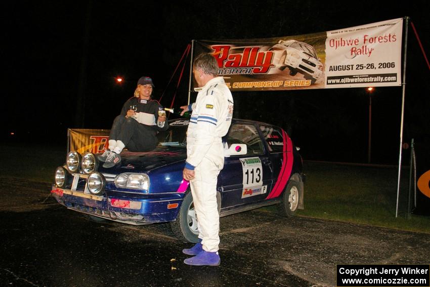 Martin Headland pours a glass of champagne for Kathy Jarvis as they were the sole finishers in Production class in their VW GTI.