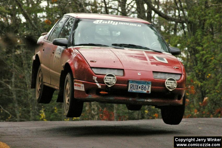 Jonah Liubakka / Craig Walli catch really nice air in their Saturn SL-2 at the midpoint jump on Brockway 1, SS11.